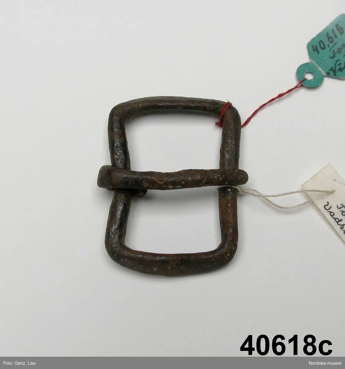 Huvudliggaren:
"3 förskinnsspännen fr. Torsö eller Viksala sn.
Från Torsön.
a. Av klockmetall; torn saknas. 5,5 x 5,7 cm.
b. 
c. Av järn med rektangulär ram. Torn löst fäst kring ramens omkrets. 4,7 cm hög; 3,4 cm bred". 