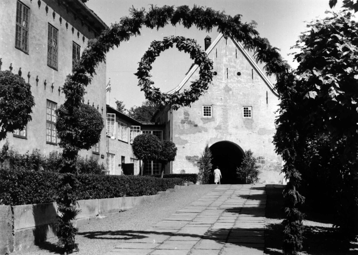 St. Hans fest på Norsk Folkemuseum i 1967. Inngangspartiet pyntet med guirlander og blomster i portal.