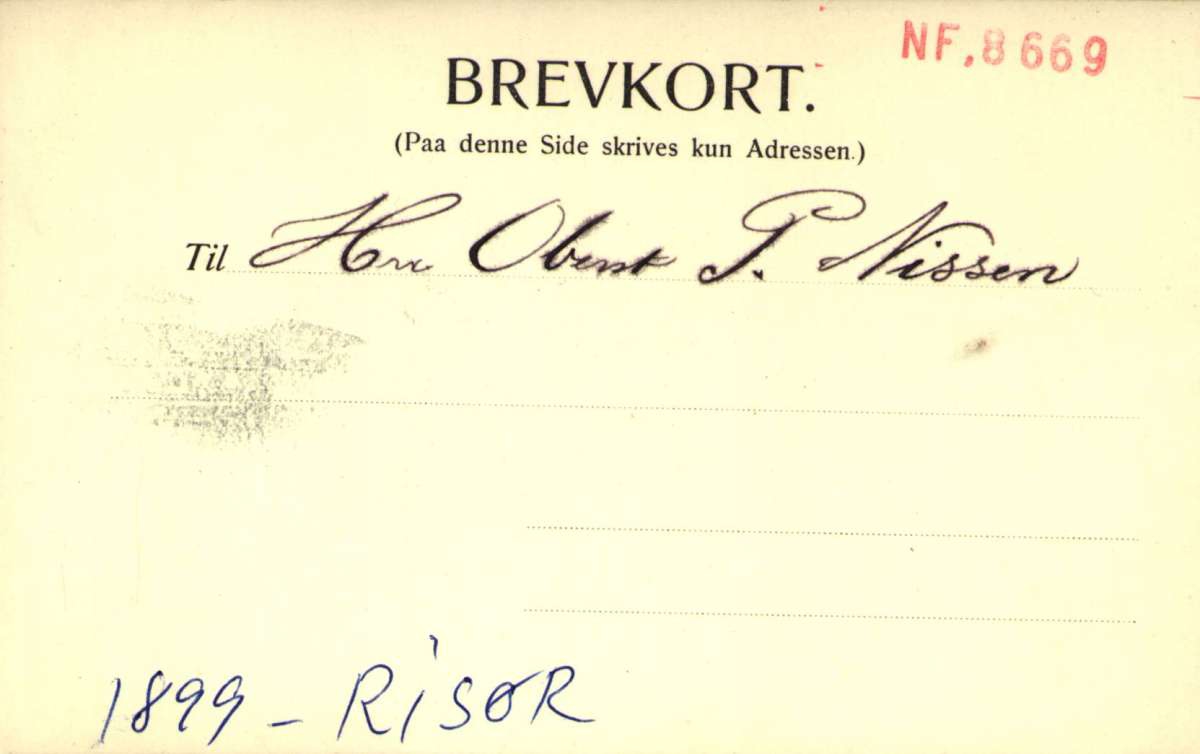 Postkort. Jule- og nyttårshilsen. Foto. Svart/hvitt. Motiv fra Risør. Kirken, folkeskolen og badehuset. Datert 24.12. 1899.