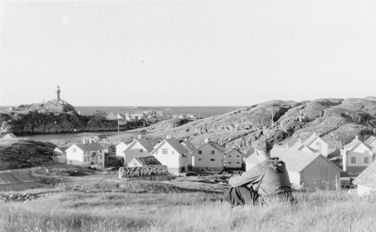 Landskap og bebyggelse i Ona på Sandøy i Møre og Romsdal. Ona fyr i bakgrunnen.