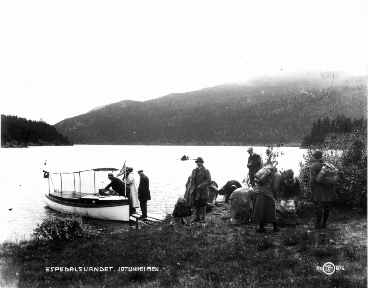 På tur ved Espedalsvannet, Vestre Gausdal. Motorbåten "Ruten" ved kai klar til å frakte reisende. Fjell i bakgrunnen.