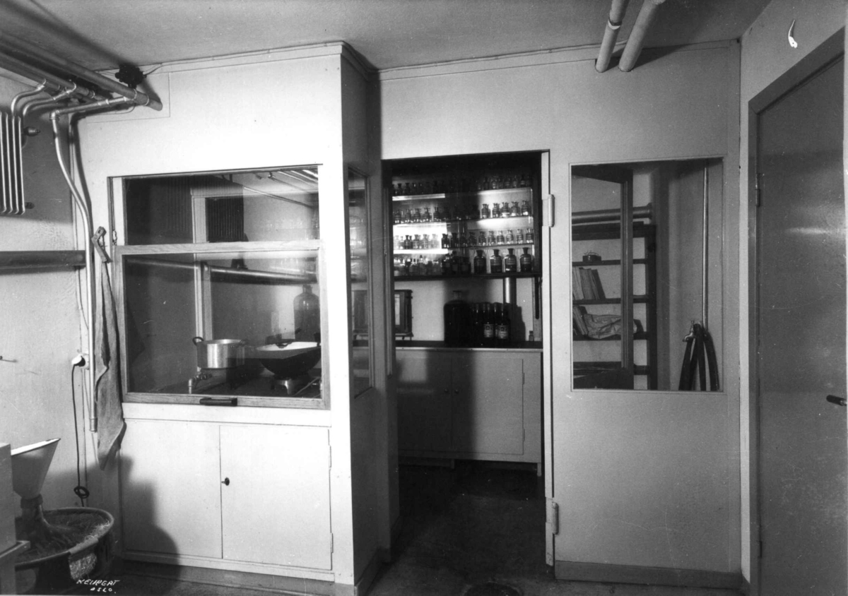 Rådhusapoteket, Oslo. 1935-1937.  Analyserom sett fra laboratoriet. Hyller med flasker.