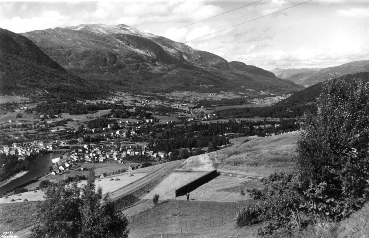 Voss 1939. Oversiktsbilde over landskap med gårder, jorder og åkrer. Høyonn.