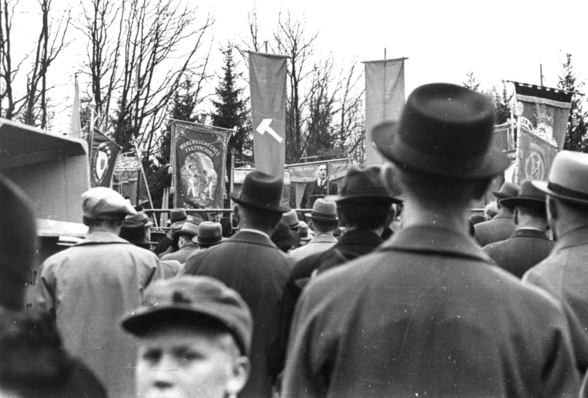 Kirkestatsråd Hjelmtveit taler i Egelunden, Kristiansand 1939. Folk står med faner og bannere.