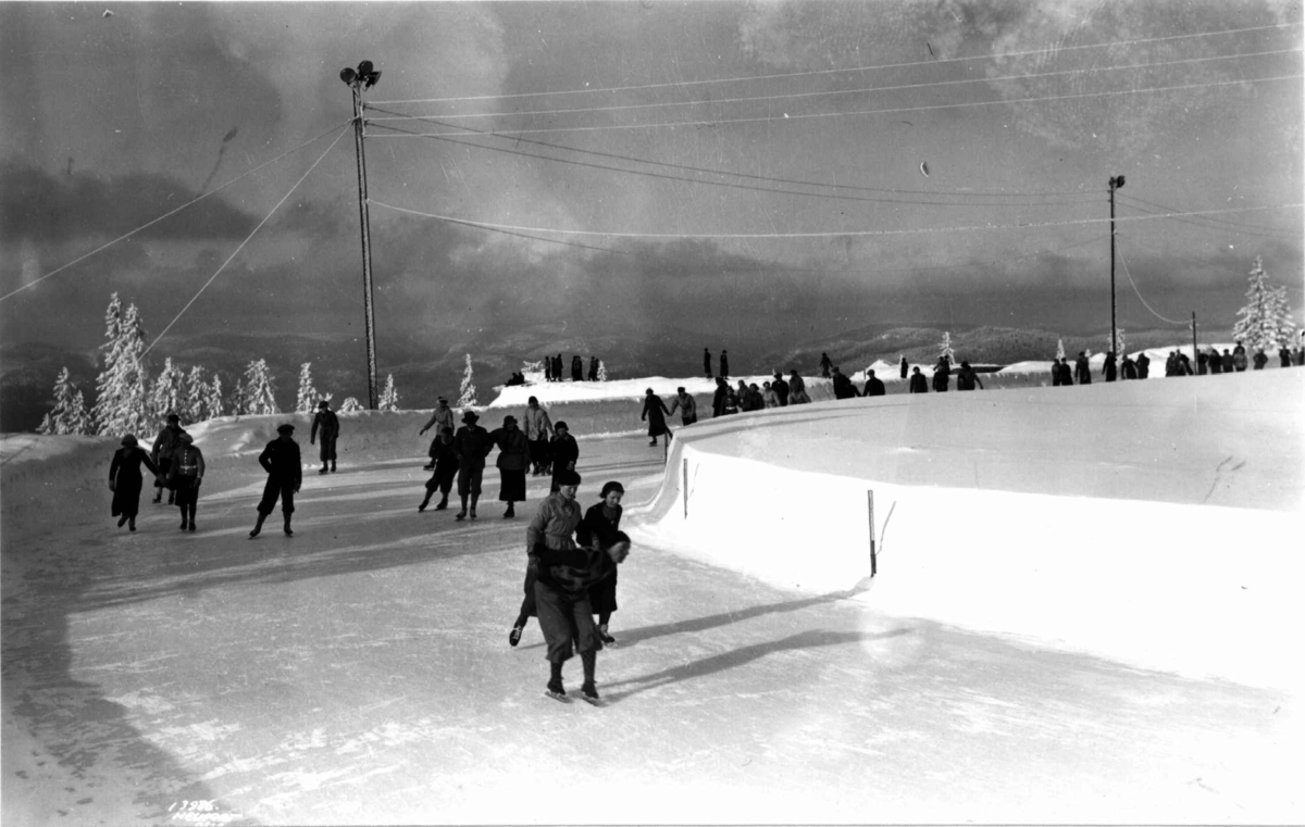 Tryvann skøytebane, Oslo. 1936. Skøyteløpere i sving på isen.