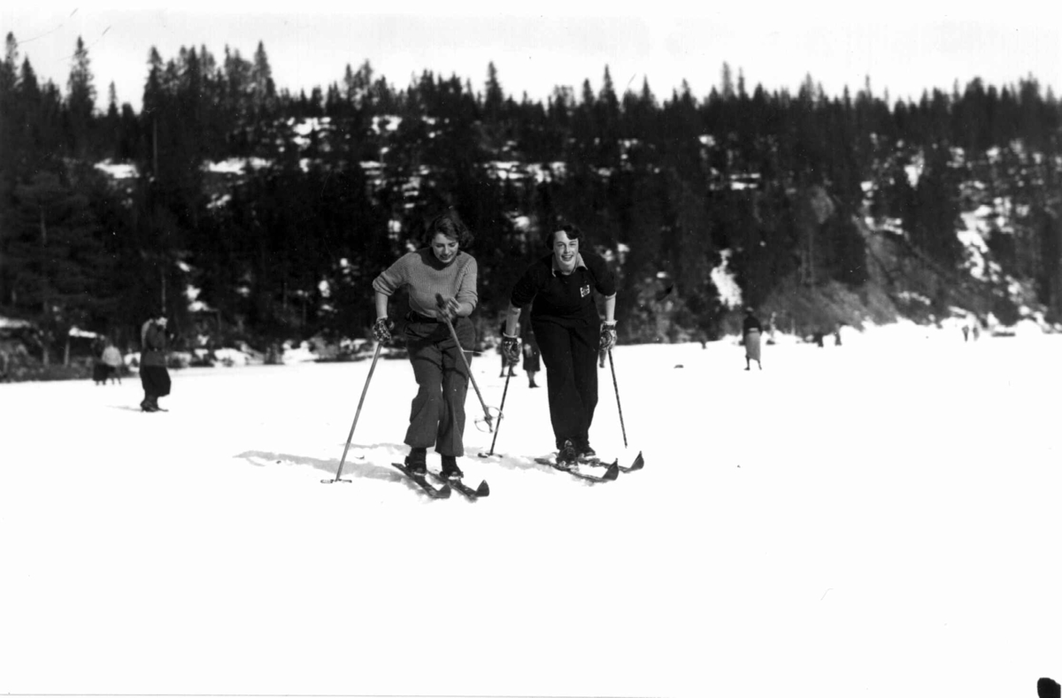 Slalåmrenn, Tryvannsåsen, Oslo. 1934. Skiløpere på Tryvann. To kvinnelige skiløpere ses i forgrunnen.