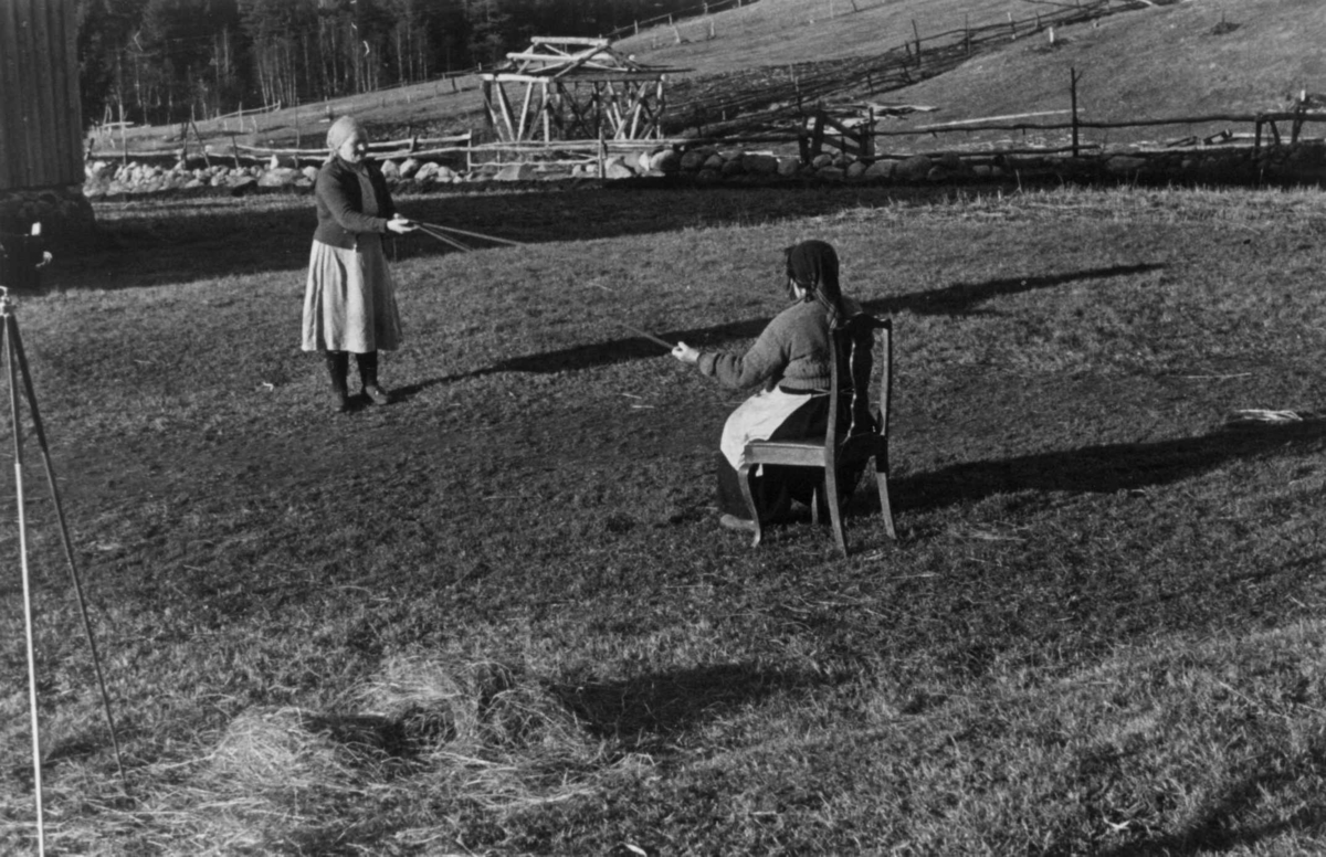 Bondekone Kristi Espeli og datteren lager snor til å ha nederst på stakk og kjoler. Åseral, Vest-Agder 1943.