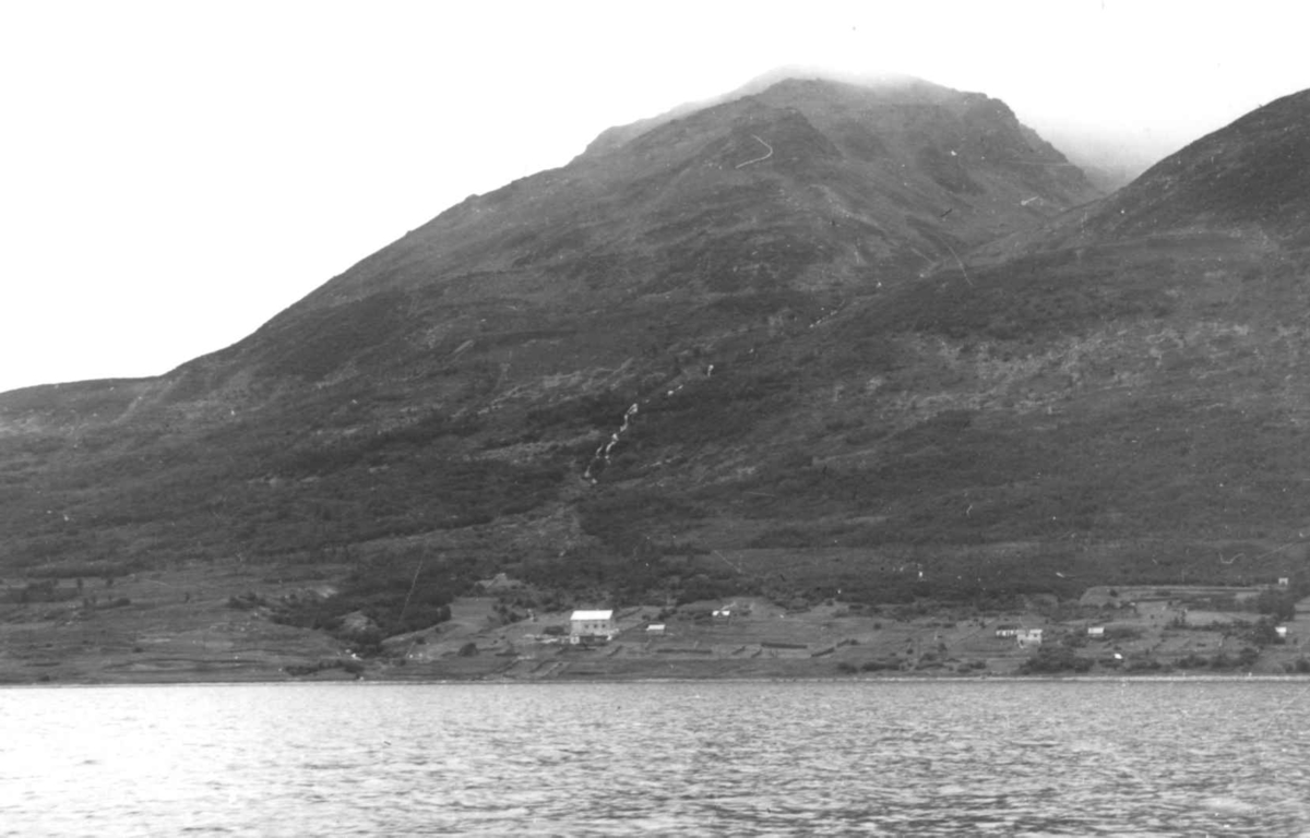 Oversiktsbilde med fjell, bebyggelse og sjø. Antagelig i Lyngen, Troms 1947.