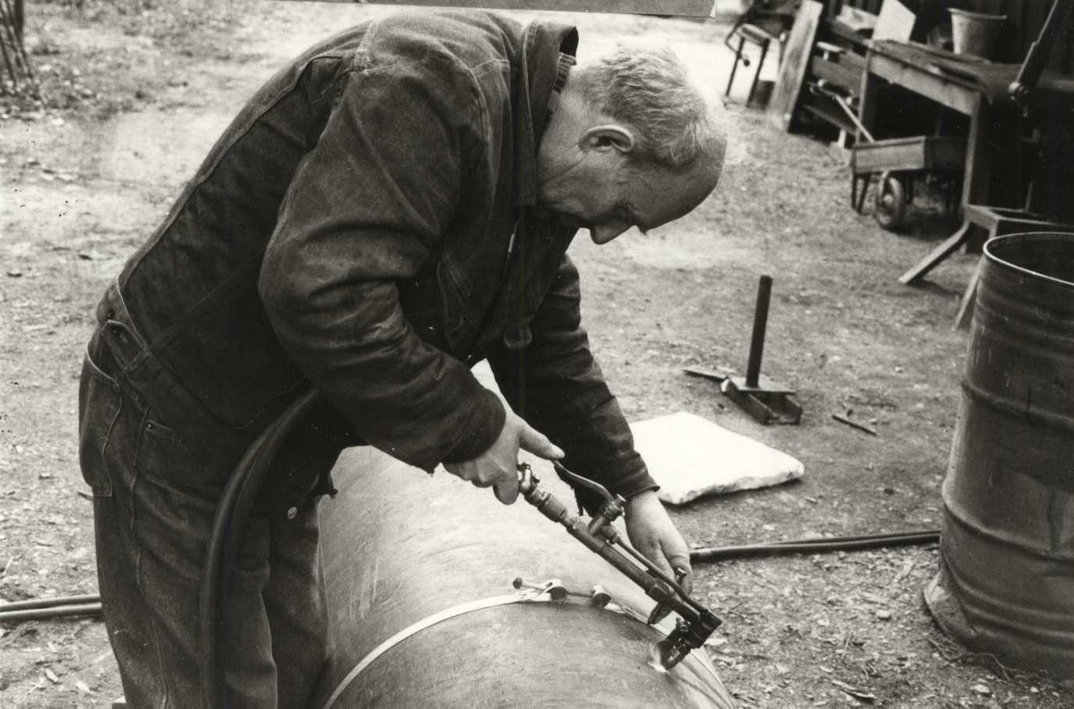 Martin Haugan i smia skjærer av et stålrør med skjærebrenner. Norsk Folkemuseum i april 1989.