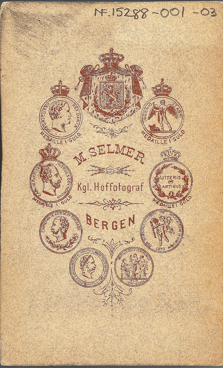 U.nr. Konedrakt fra Hardanger. Portrett av kvinne stående ved høyrygget stol ant. i fotoatelier med nøytral bakgrunn og mønstret gulvteppe. 
Fra serien "Norske Nationaldragter", visittkortformat, håndkolorert. Serien er tatt av fotograf Marcus Selmer (1819-1900), Bergen.
