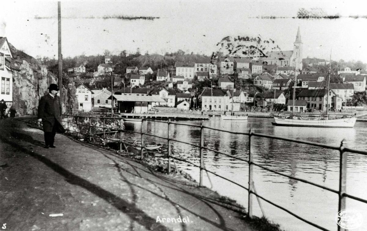 Arendal, Barbubukt, med Barbu kirke, reist 1880 og havneområde. Seilskute fortøyd. Kystveien går langsmed sjøen fra Arendal sentrum og østover.