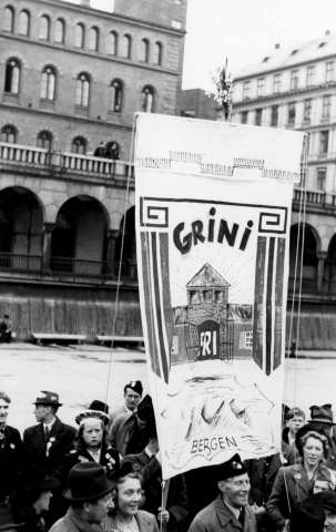 Fra fredsdagene i 1945. Fra Youngstorget med Møllergata 19 i bakgrunnen. Fane merket med Grini, fri og Bergen