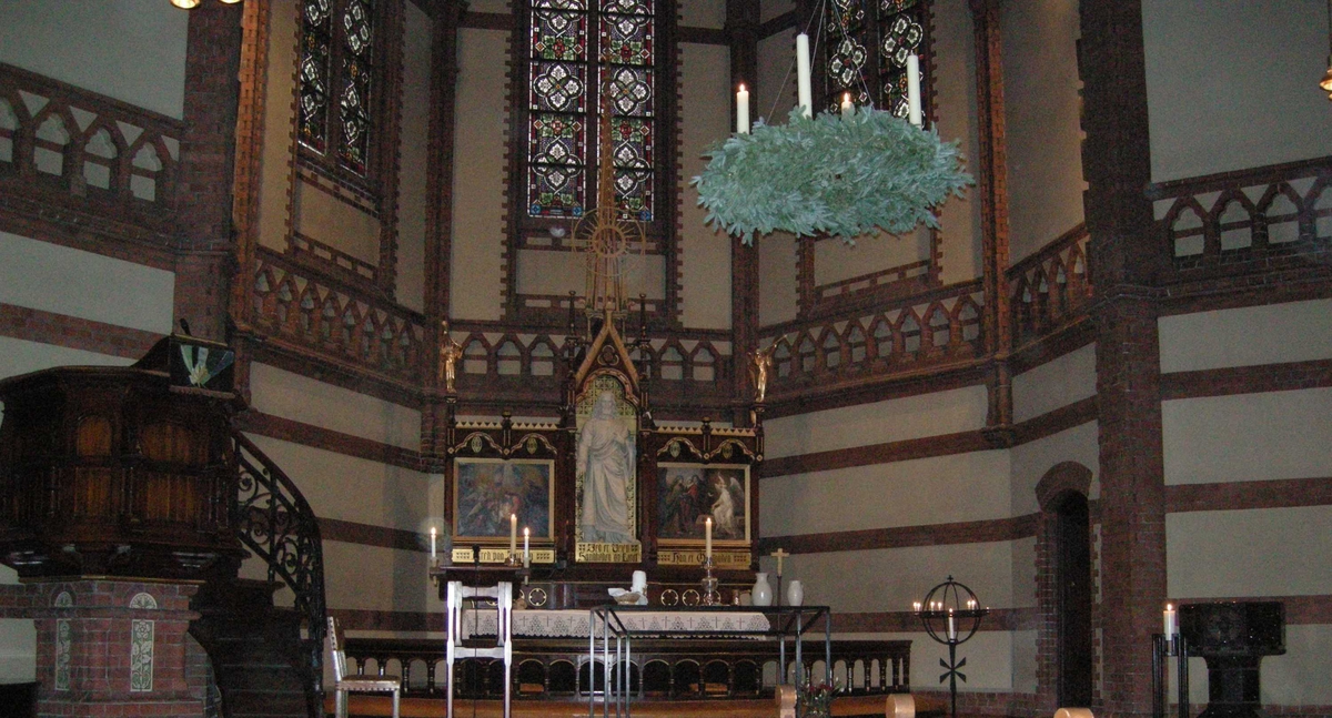 Paulus kirke i Oslo, 2. søndag i advent, 09.12.2007. Fra kirkerommet. Krans av granbar med fire hvite lys henger i taket over midtgangen foran koret. Prekestol, alter, altertavle, døpefont og lysglobe i bakgrunnen.