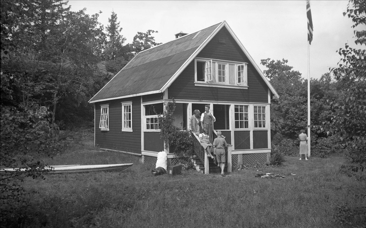 Flere mennesker på trappen på hytta til Smith på Storøya ved Sandefjord, Vestfold. Fotografert 1937.