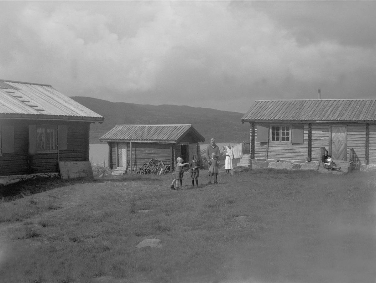 Barn leker på gårdstunet ved Orfisken tilhørende Johan Paulsson , Rukkedalen, Buskerud. Fotografert 1936.