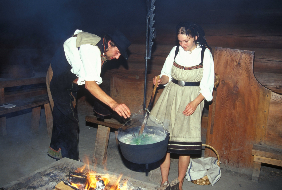 Verter i drakter ved åra i Sagastua, bygning nummer 15 på Norsk Folkemuseum, der det brygges mjød.