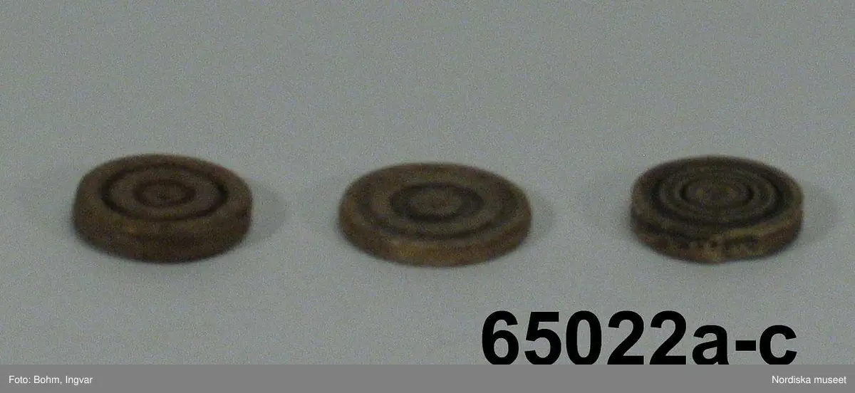 Huvudliggaren:
"Brädspelsbrickor fr. Island. Af ben 3 olika, med insvarfvade koncentriska ringar å ena sidan."