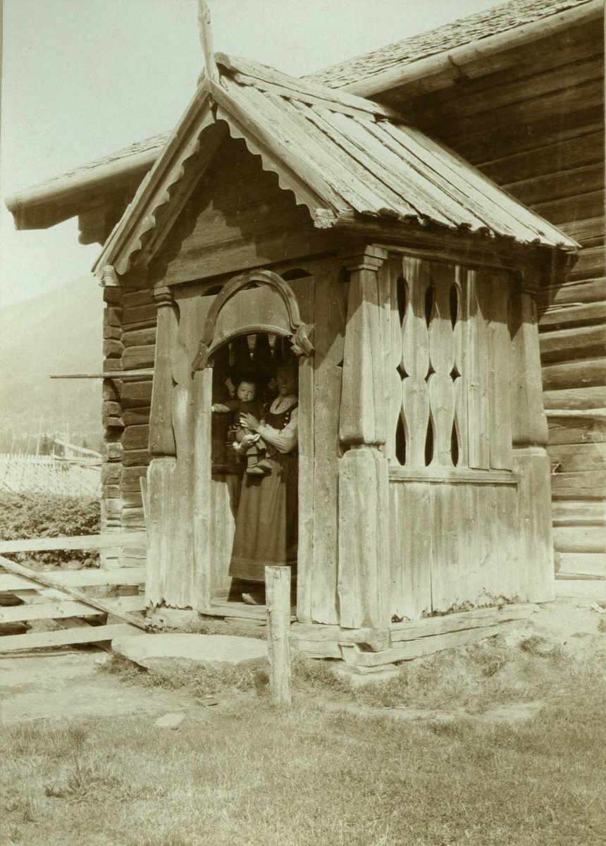 Inngangsparti, Baklien, Tinn, Telemark. Kvinne i døren med barn på armen. Fotografert 1907.