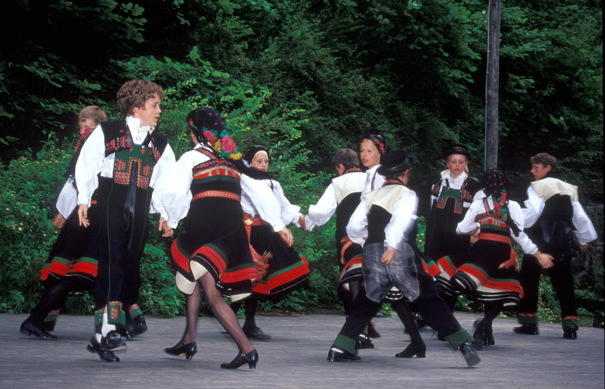 Norsk Folkemuseums dansegruppe, kledd i folkedrakter, danser folkedans i friluftsteateret NF 349.