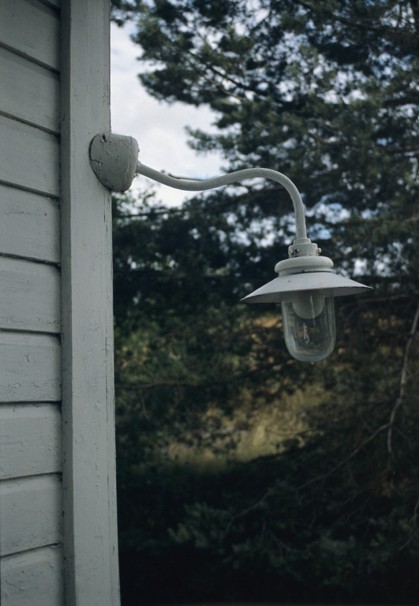 Gammel lampe på hushjørne i Lillesand. Illustrasjonsfoto for Bonytt 1986.
