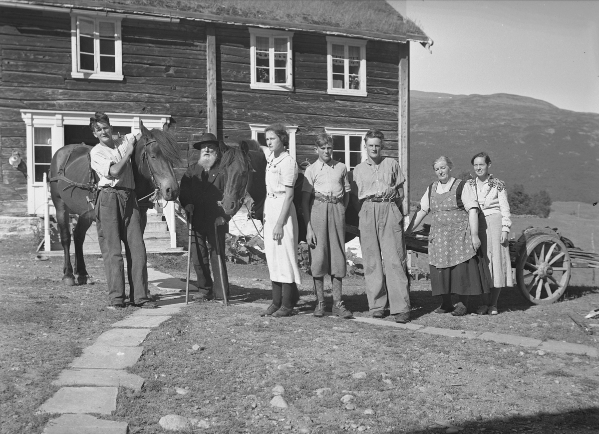 Familie fotografert foran våningshus, Ekran, Rise, Drivdalen, Oppdal, Sør-Trøndelag. Fotografert 1938. 