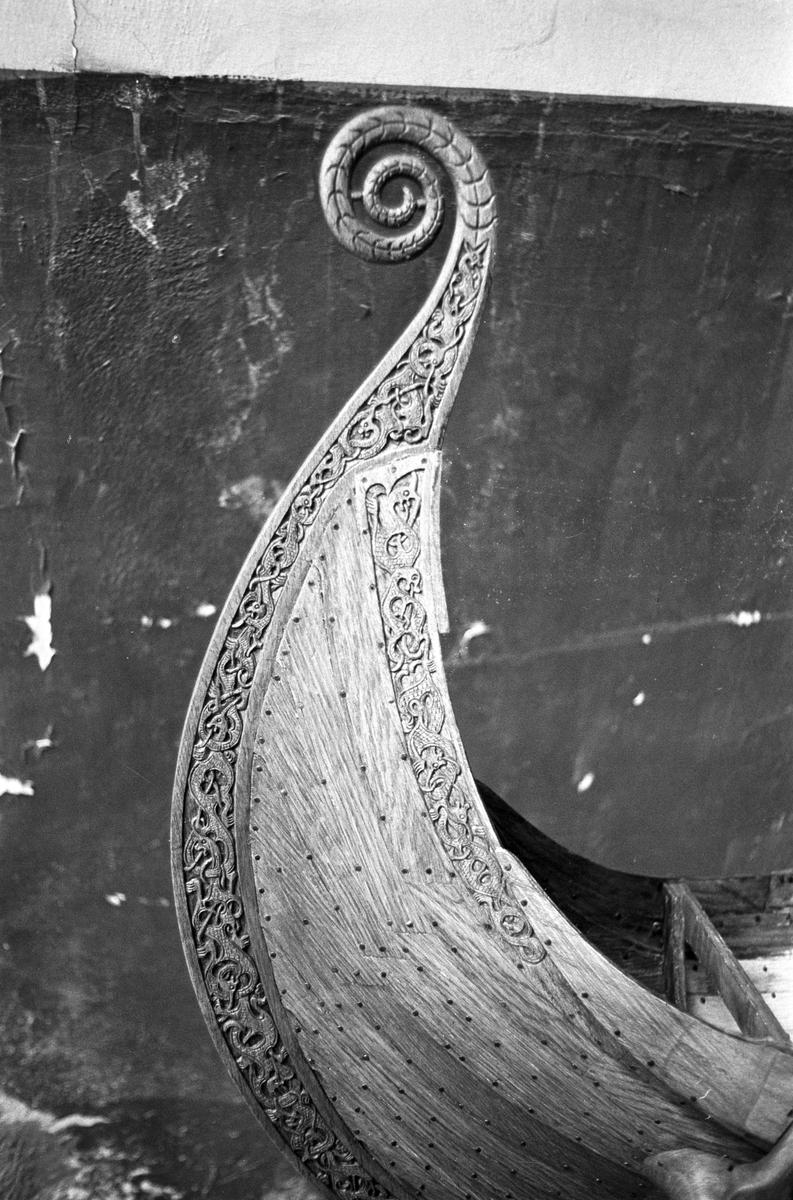 Serie. To menn bærer ut en modell av vikingeskipet "Osebergskipet" av en kjeller. Fotografert 1967.