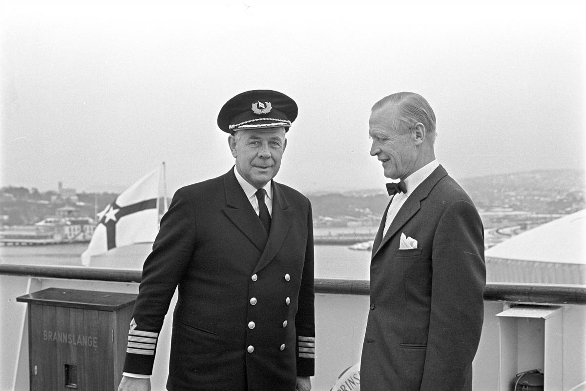 Serie. Fergen "Prinsesse Ragnhild" ligger til kai på Hjortneskaia. To menn hilser på hverandre, den en er ant. kapteinen om bord. Fotografert november 1966.