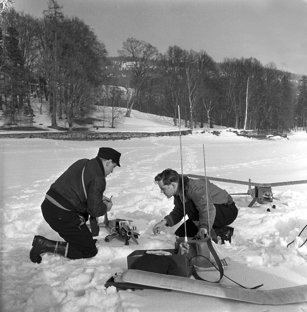 Serie. Modellflyentusiaster reparerer og sender opp flyene sine på Bogstadvannet. Fotografert 31. mars 1956.
