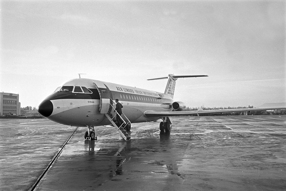 Serie. Menn fra Braathens SAFE inspiserer jetflyet fra "Aer lingus irish international". Et propellfly er i ferd med å lette i bakgrunn. Fotografert oktober 1965.