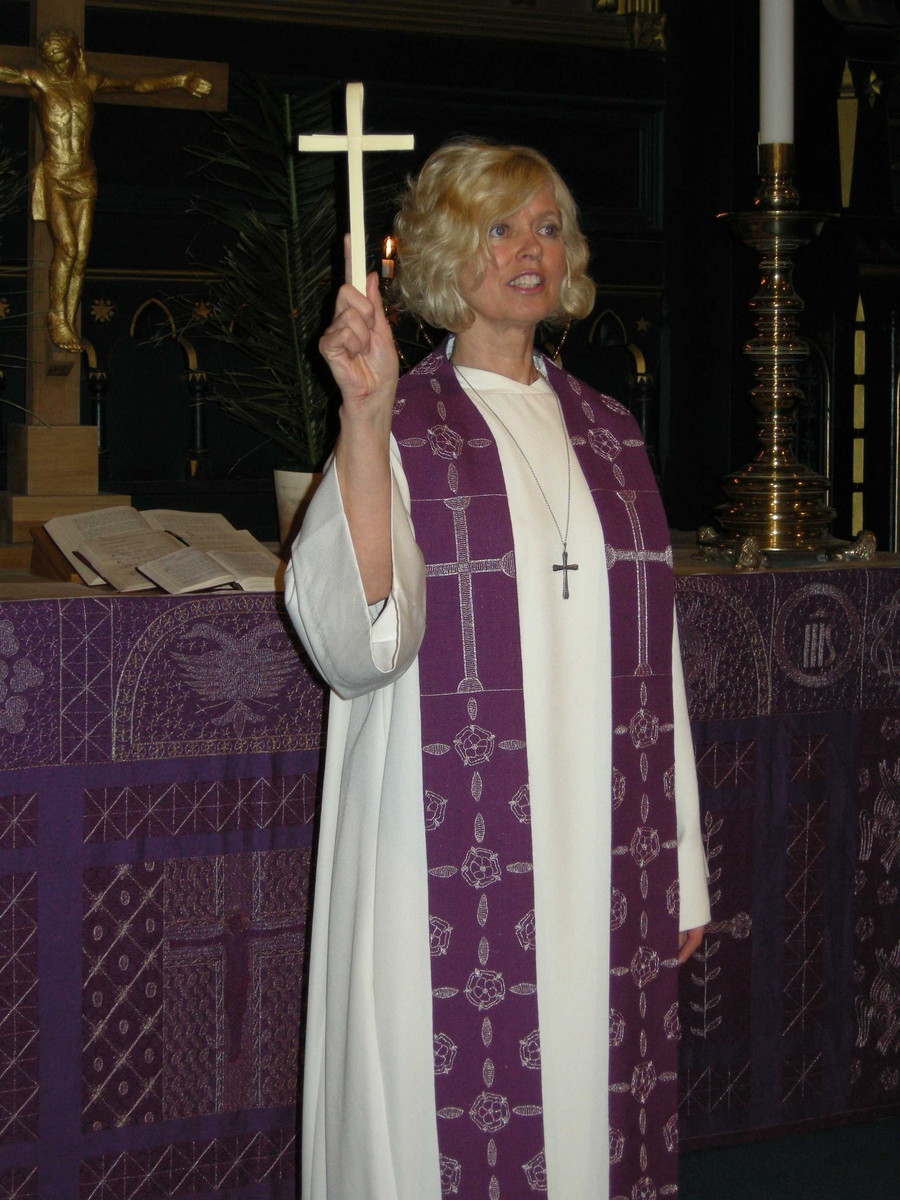 Domkirken i Kristiansand. Palmesøndag, 16.03.2008. Velsigning av palmekors. Serie bilder med kapellan Birte Løvåsen kledd i hvit alba og lilla stola ved koret i kirken. Palmeblader. Kors. Kirketekstilene er utført av Borgny Farstad Svalastog.  