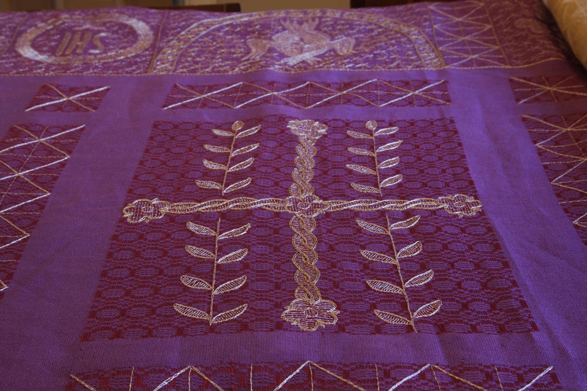 Detaljer fra påskegudstjenestene påsken 2008 i Kristiansand Domkirke. Detalj av lilla kirketekstil, laget av Borgny Farstad Svalastog. IHS-monogram (Kristusmonogram) øverst til venstre.