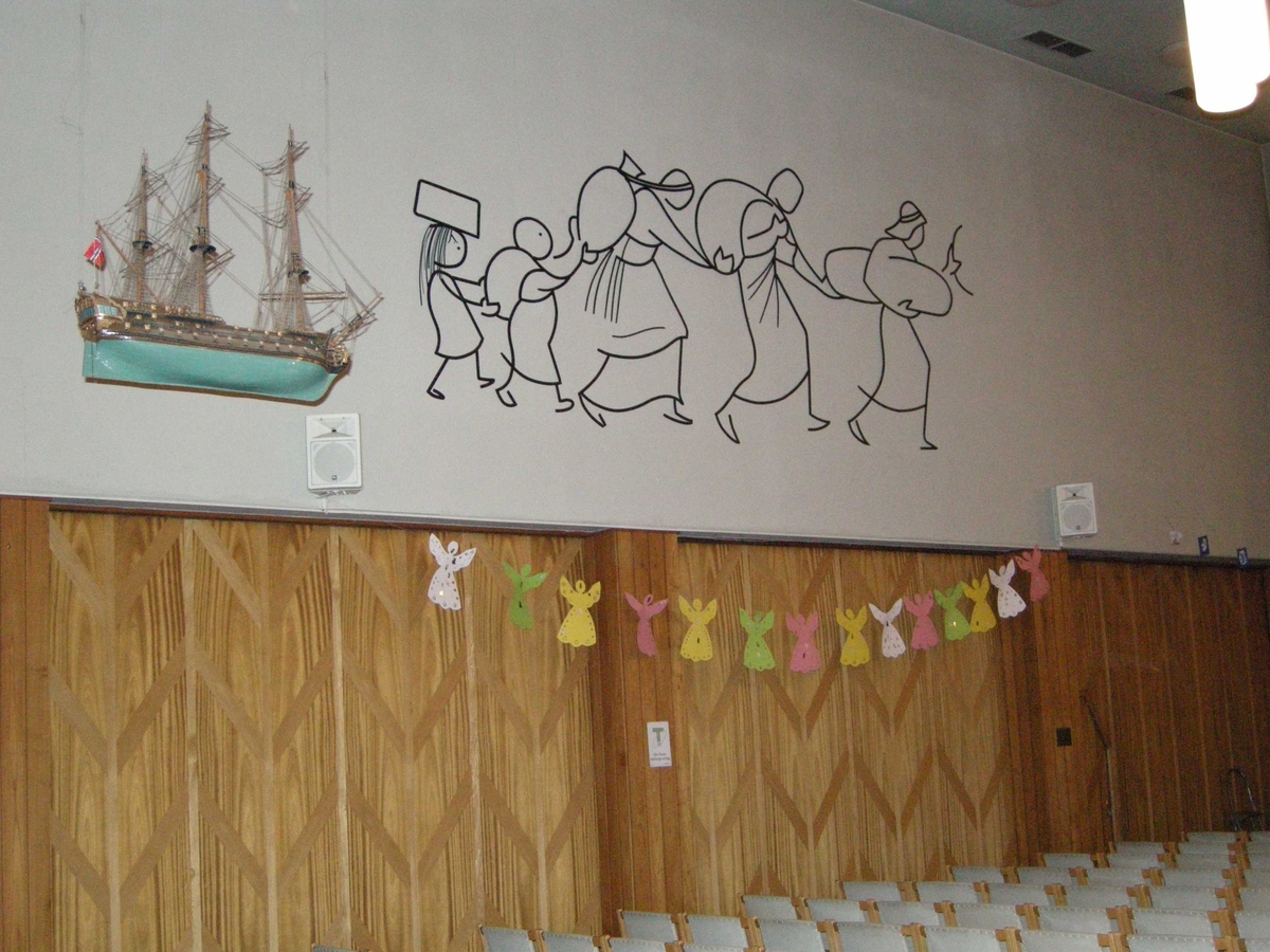 1. juledag i Tonsen kirke, Oslo. 25.12.2007. Kirkeinteriør. Veggutsmykning. Kirkeskip henger i taket. Englepynt i papir, laget av barn.