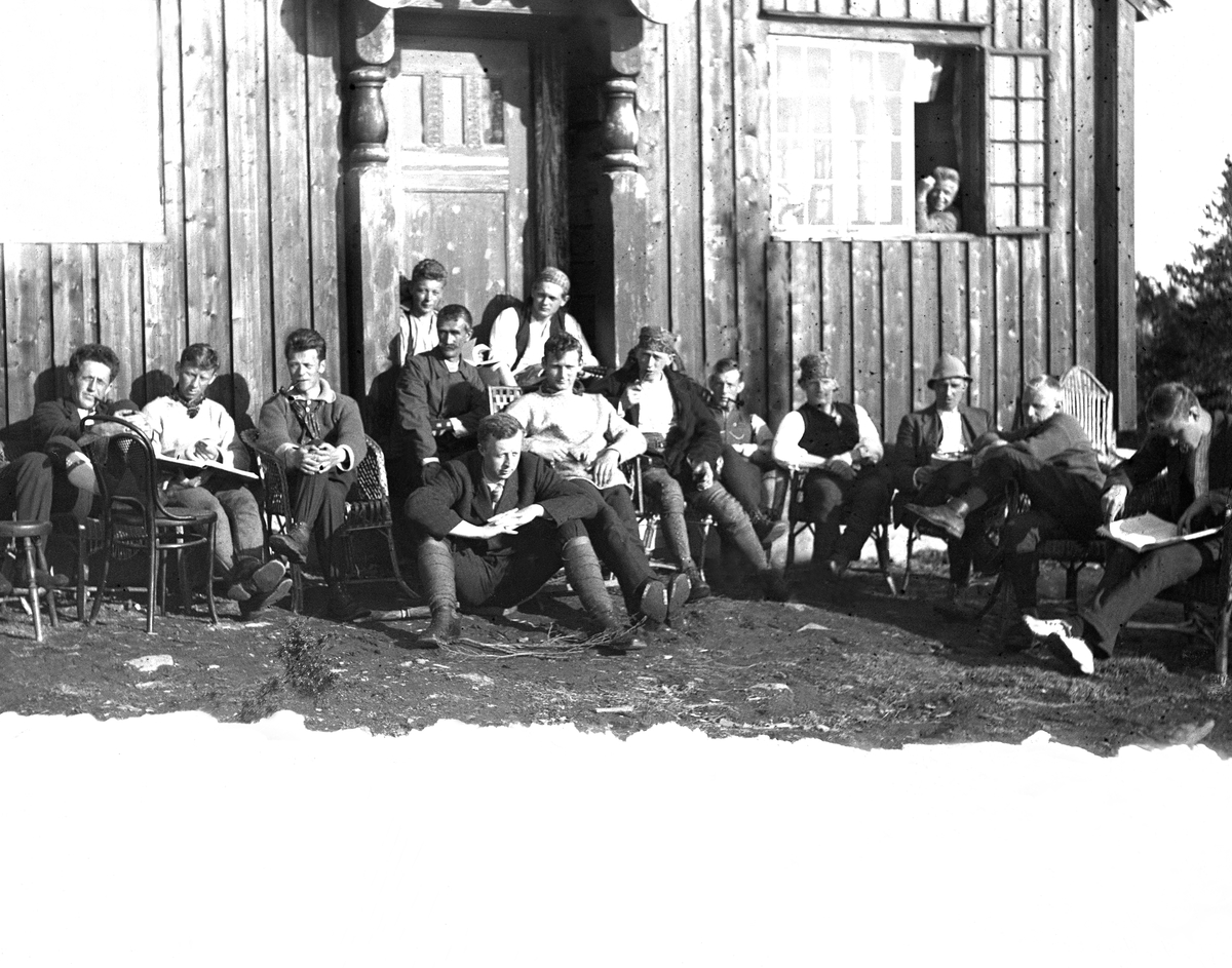 Studenter samlet på sydsiden av Studenterhytta i Bymarka i forbindelse med et skirenn ("Saloskirennet"?). Fotografert 1921.