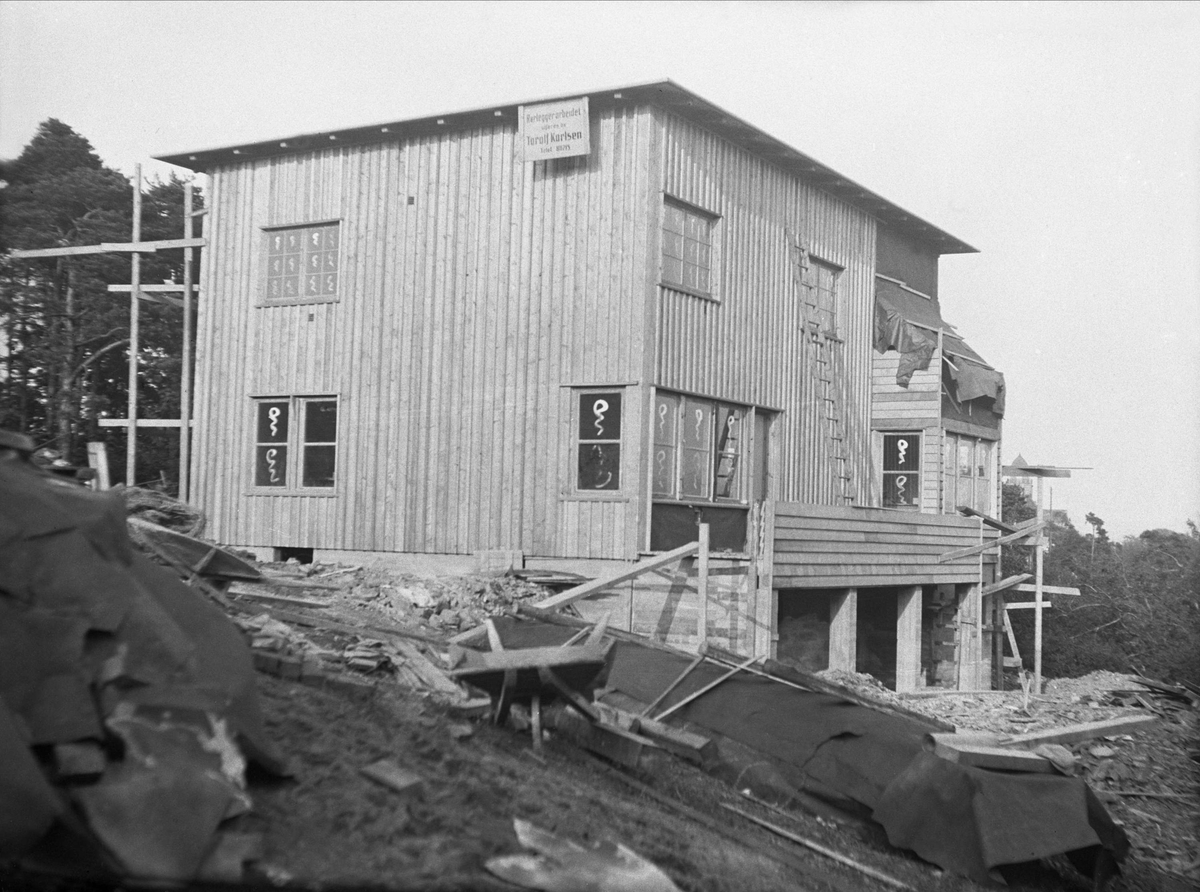 Boligen i P.T. Mallings vei 4 er under tak og panelet. Plakat med "Rørleggerarbeidet utføres av Torolf Karlsen" henger på huset.  Fotografert september 1929.