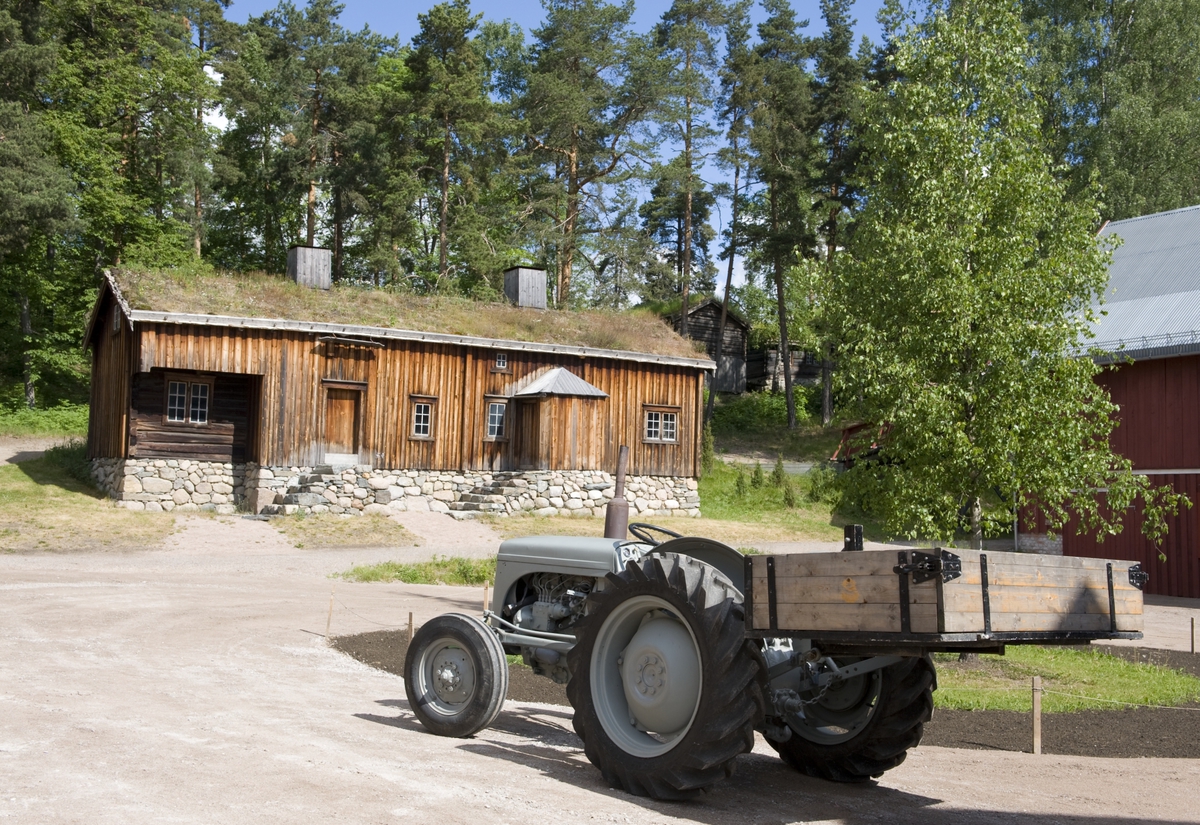 Trøndelagstunet på Norsk Folkemuseum, juni 2010. Traktor på tunet. Hus fra Hovde, Ørlandet, i bakgrunnen.