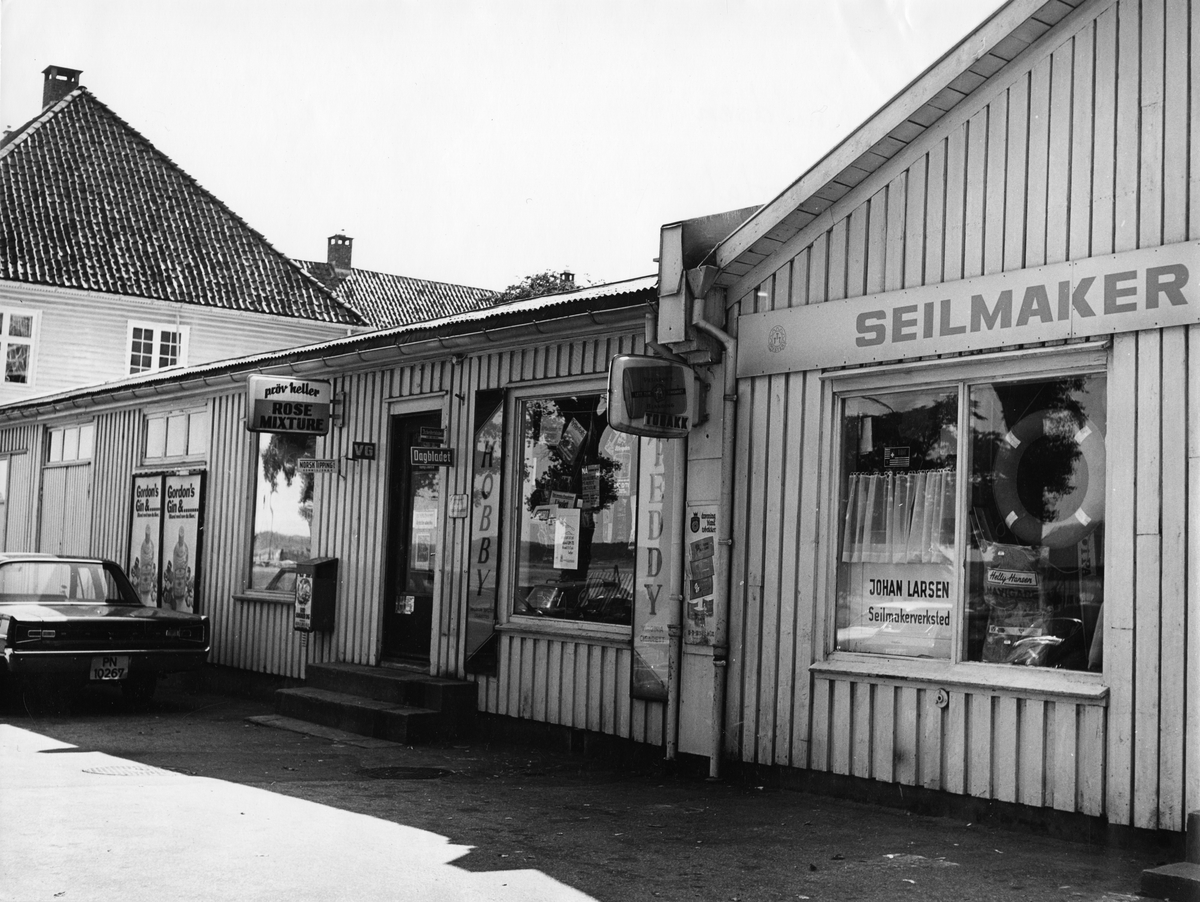 Gatebilde. Kiosk med reklame for tobakk rundt vinduet.