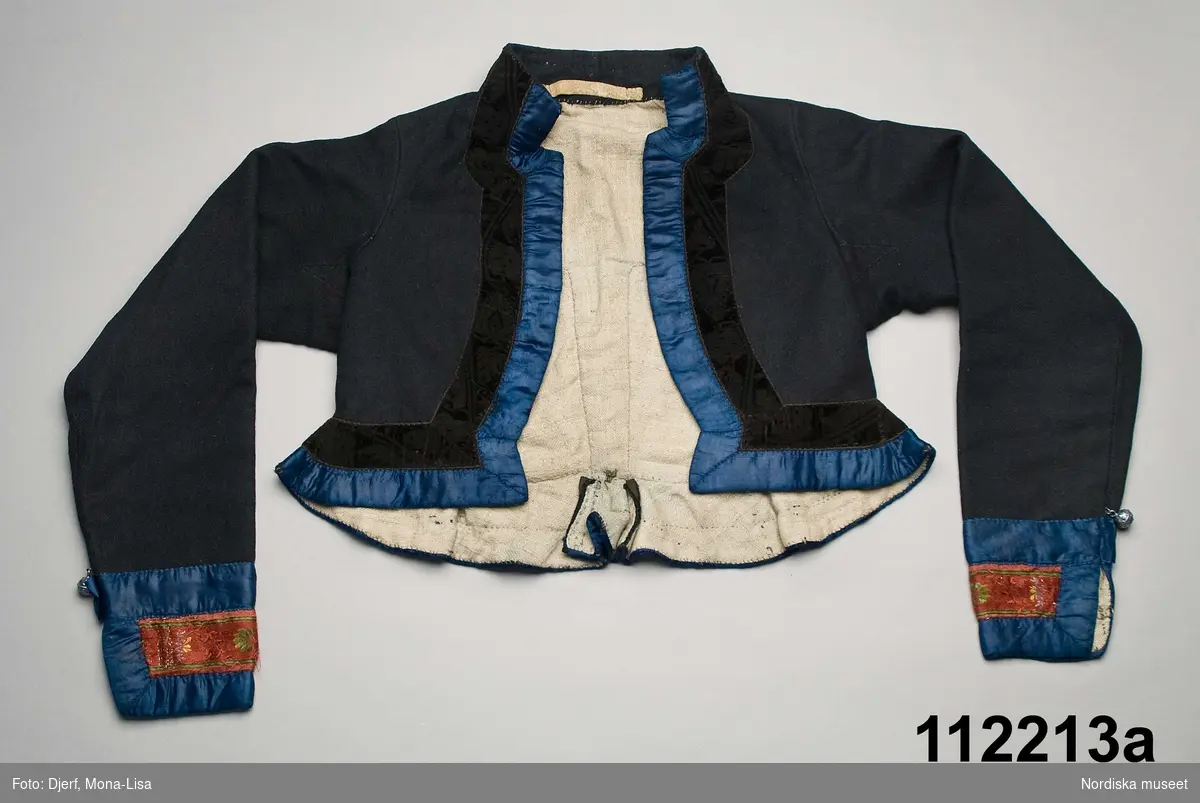 a. Kvinnotröja av blåsvart fin vadmal.  3 cm breda klarblå sidenband och 3,5 cm brett svart sammetsband med invävt bladmönster.
b. Kjol av svart kläde
/Berit Eldvik 2010-11-23