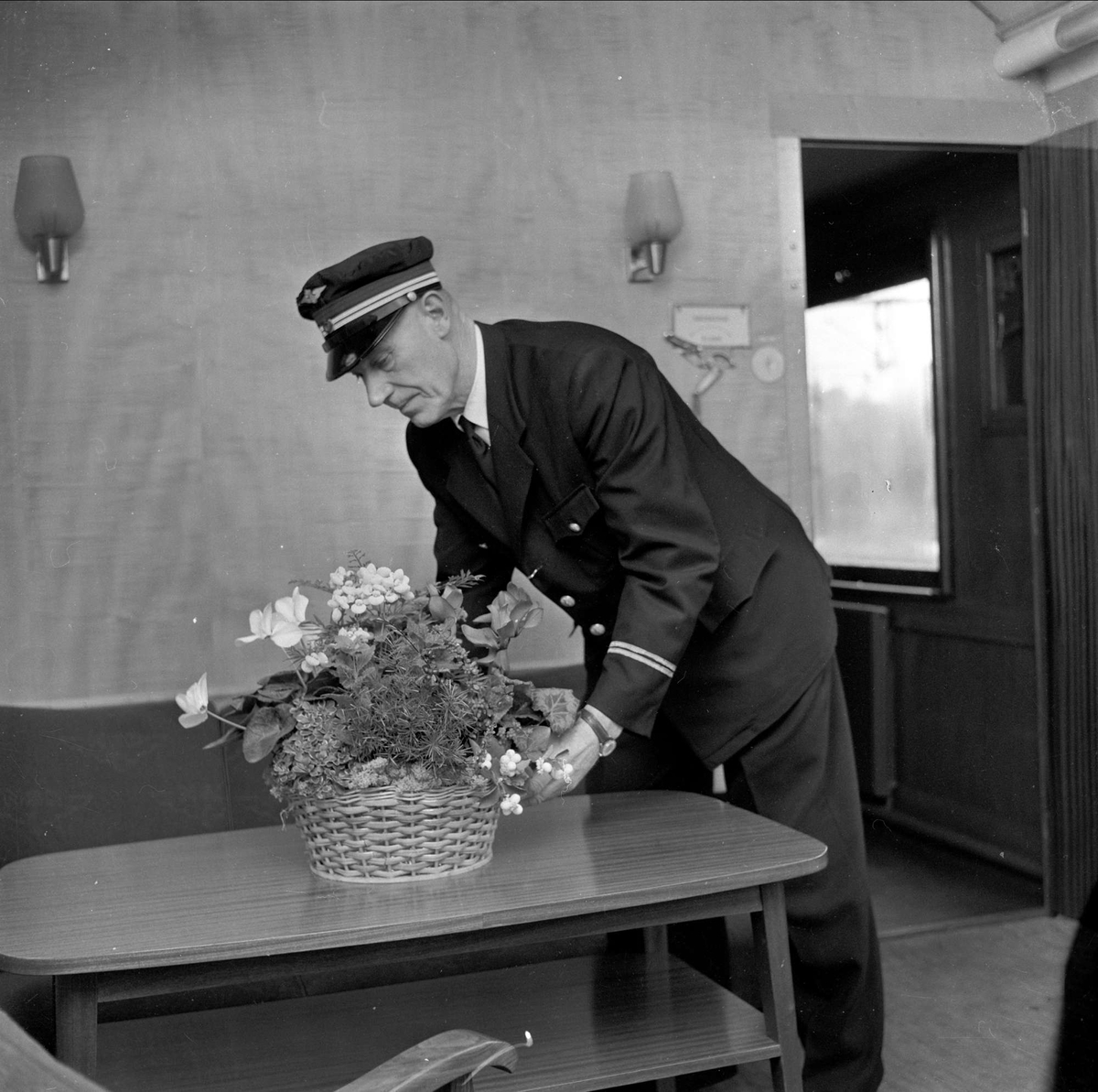 Jernbanekonduktør med blomster. Oktober 1959.