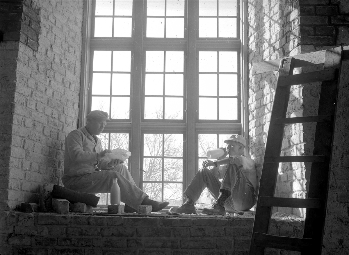 Akershus Slottskirke, Oslo, 07.04.1954. Håndverkere lunch i vinduskarm.