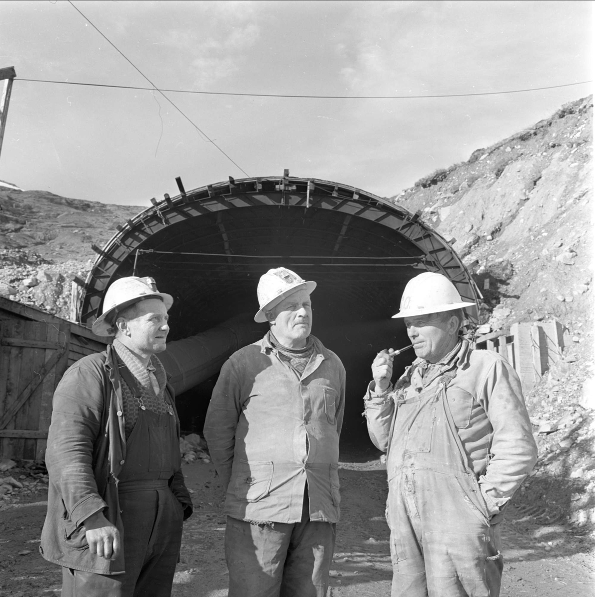 Haukeliveien, anleggsarbeidere foran tunnelåpning, Vinje T, Haukeli, oktober 1962.