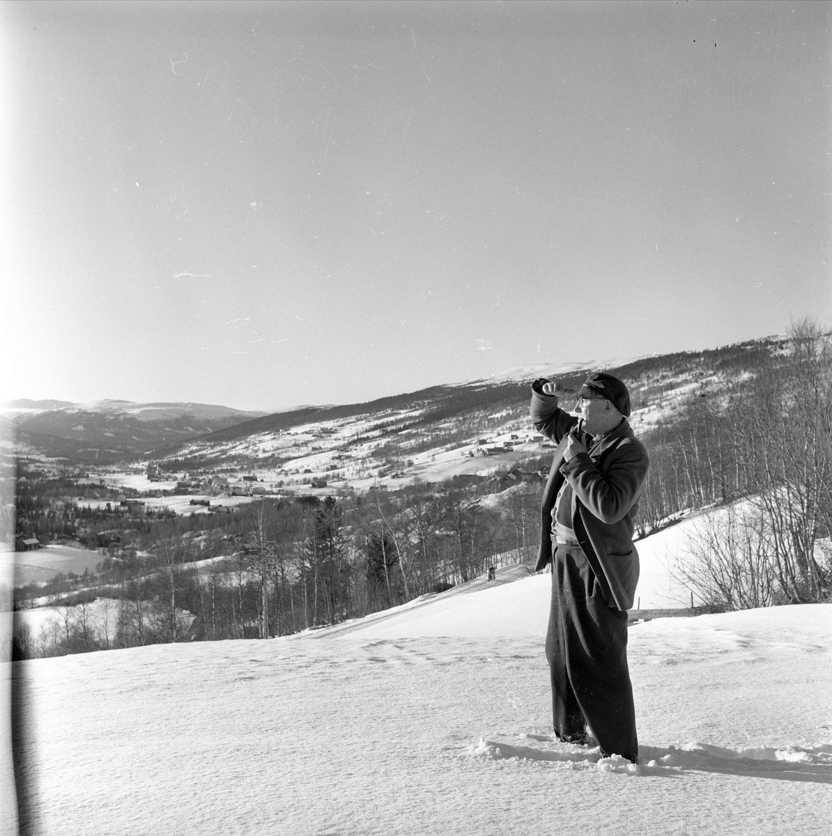 Dombås, Dovre, 21.03.1959. Utsiktsbilde. Mann i snøen.