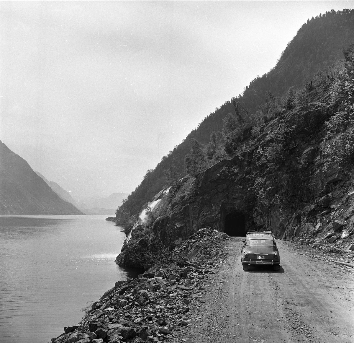 Sørfjorden i Hardanger, Hordaland, mai 1963. Bil på landevei.