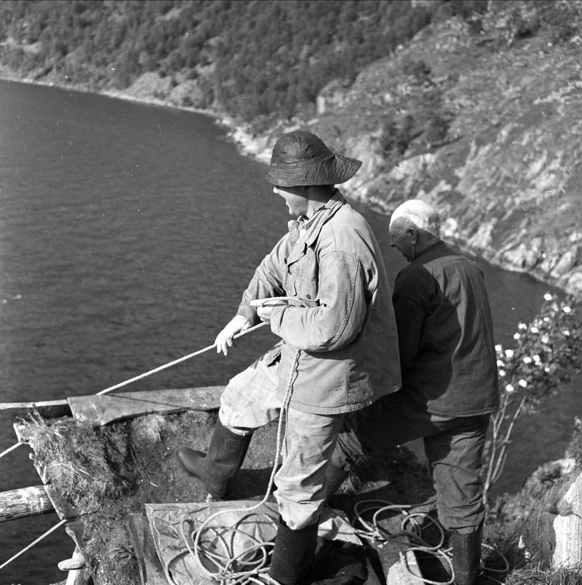 Laksefiske hos Johan Leknes i Hjørundfjorden, Ørsta, Møre og Romsdal, 12.07.1958. Fiskere på plattform over vannet.