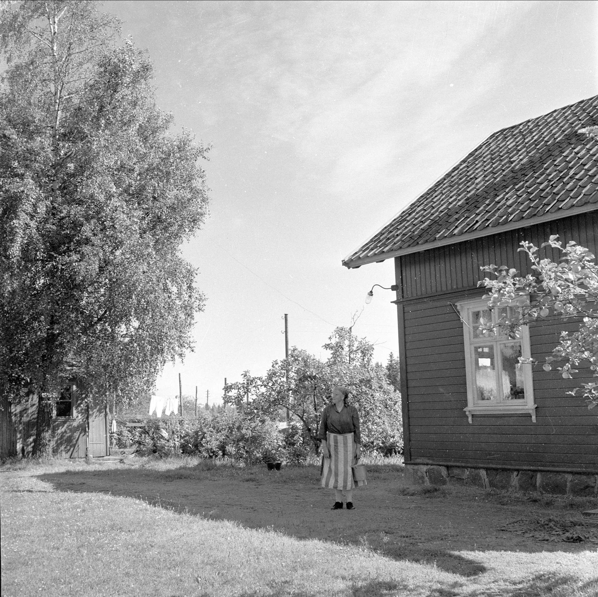 Rygge, Østfold, 13.08.1958. Hus i nærheten av flyplassen. Kvinne foran hus.