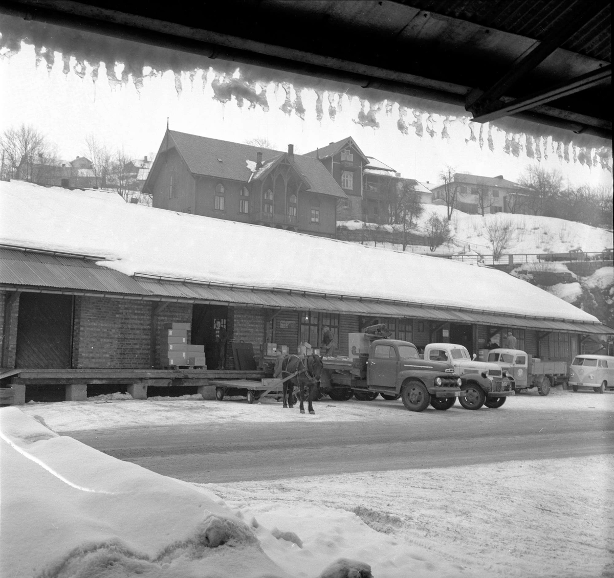 Skien, Telemark, mars 1958. Byjubileum. Bygninger og lastebiler.
Lastebilene til venstre er (fra venstre Amerikansk Ford) 1951-52 og Dodge 1946-47.