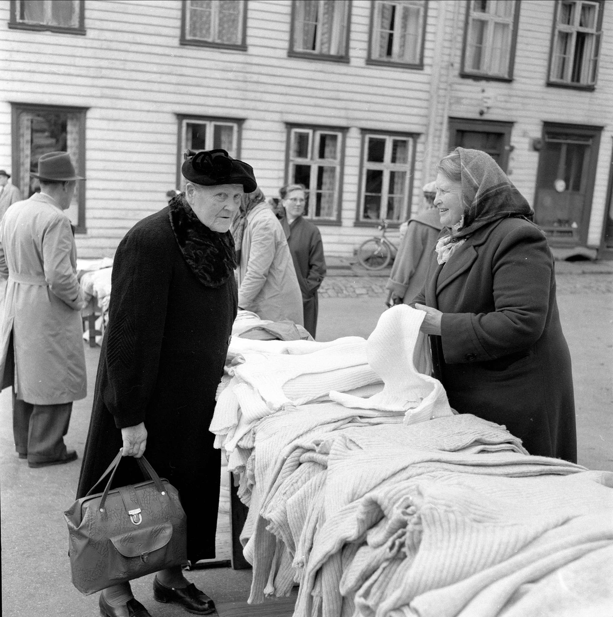 Stavanger, Rogaland, oktober 1957. Fra torghandel, kvinne selger strikkeplagg fra langbord.