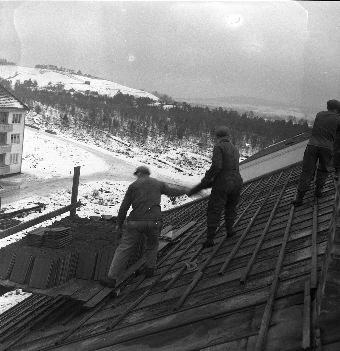 Lillestrøm, Skedsmo, Akershus, desember 1952. Boligbygging, arbeidere på tak. Legging av takstein.