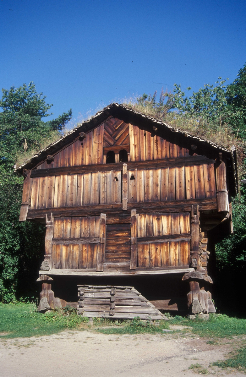 LOFT FRA SØRE RAULAND, NORE OG UVDAL, BUR ETTER 1209, LOFT ETTER 1594 
Overført til museet 1945, gjenoppført 1945 

«Buret», det vil si første etasje, var forrådsrom for mat. «Loftet», altså andre etasje, ble brukt til forrådsrom for klær og tekstiler, og innredet med senger til soveplasser. På alle fire sider er den laftede bygningskjernen omgitt av en sval i stavverk. Da buret ble oppført sto det direkte på laftesteiner eller på en lav grunnmur. På 1700-tallet ble imidlertid hele bygningen løftet opp og satt på stabber. 

Denne bygningen er etter bygningshistorikeres definisjon et loft, fordi den har to etasjer og trapp utenfor laftekjernen, og fordi rommet nede bruktes til mat. Men i Nore og Uvdal kalles hele huset gjerne «bur» eller «stabbur». Stabbur med bare én etasje kalles «veslebur». 

(Tekst hentet fra By og bygd 43, 2010)
