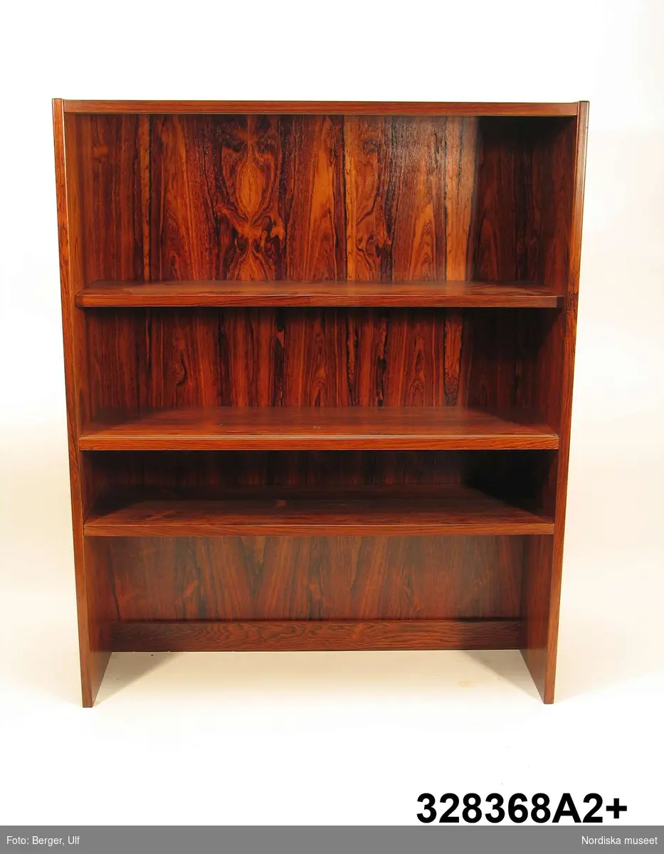 a-e:
Bokhylla, "Excellent",  med TV-bänk samt bar- och vitrinskåp, jakarandafaner på spånskiva, IKEA, 1968. 

Hyllan består av fyra sektioner med hyllor löst placerade på underredet. Skåp- och byråunderdelar med ryggar av masonit, fastnitade. Kvadratiska ben, fastskruvade i underredet. Lådsidor m.m. av björk och lådbottnar av vitlackerad masonit. Flyttbara hyllplan. Draghandtag och gångjärn av mässing.  Enligt IKEA-katalogen 1968 är ytan plastbehandlad.

Hyllan uppställd, från vänster till höger:
a:1+) Skåp med två dörrar samt a:2+) hyllöverdel, ett fast och två flyttbara hyllplan. Överst vitrindel med två skjutdörrar av glas (höjd 53,5 cm, bredd 41,5 cm).
b:1+) Byrå med tre lådor samt b:2+) hyllöverdel med tre flyttbara hyllplan. 
c:1+) Tv-bänk med en låda samt c:2+) hyllöverdel med tre flyttbara hyllplan.
d:1+) Skåp med två dörrar samt d:2+) hyllöverdel med 1 flyttbart hyllplan. Överst vitrindel med två skjutdörrar av glas (höjd 53,5 cm, bredd 41,5 cm), därunder ett barskåp med spegel som bakvägg, utrymme för flaskor till vänster och två glashyllor (48 x 19,5 cm) till höger. Barskåpet med fällbar klaff med lås. Belysning monterad i skåpets överkant.
e) Nyckel till barskåpets klaff. L 4,3 cm.

Möbeln har använts av givarinnan, Berith Helldén, f. 1945, hemmafru, och hennes man, Lars-Göran Helldén, f. 1946, inköpare, Tungelsta. Paret gifte sig 1967 och bodde som nygifta i en liten lägenhet i Borås. När de fick möjlighet att flytta till en större lägenhet i samma stad, utökades vardagsrumsmöblemanget. Hyllan inköptes 1968 på IKEA i Älmhult. Enligt IKEA-katalogen 1968 kostade de fyra hyllsektionerna totalt 2484 kronor. Hyllan har använts som förvaringsmöbel i vardagsrummet i Borås och i familjens nuvarande bostad i Tungelsta fram till våren 2005, då den inköptes av museet.

Hyllans innehåll har dokumenterats och en utförlig intervju med Berith Helldén har gjorts 2005-05-09 (se arkivreferens).
/Anna Womack 2005-10-18
