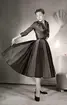 Kvinnlig modell visar en klänning från Christian Dior, september 1951. NK (Nordiska Kompaniet) Stockholm.